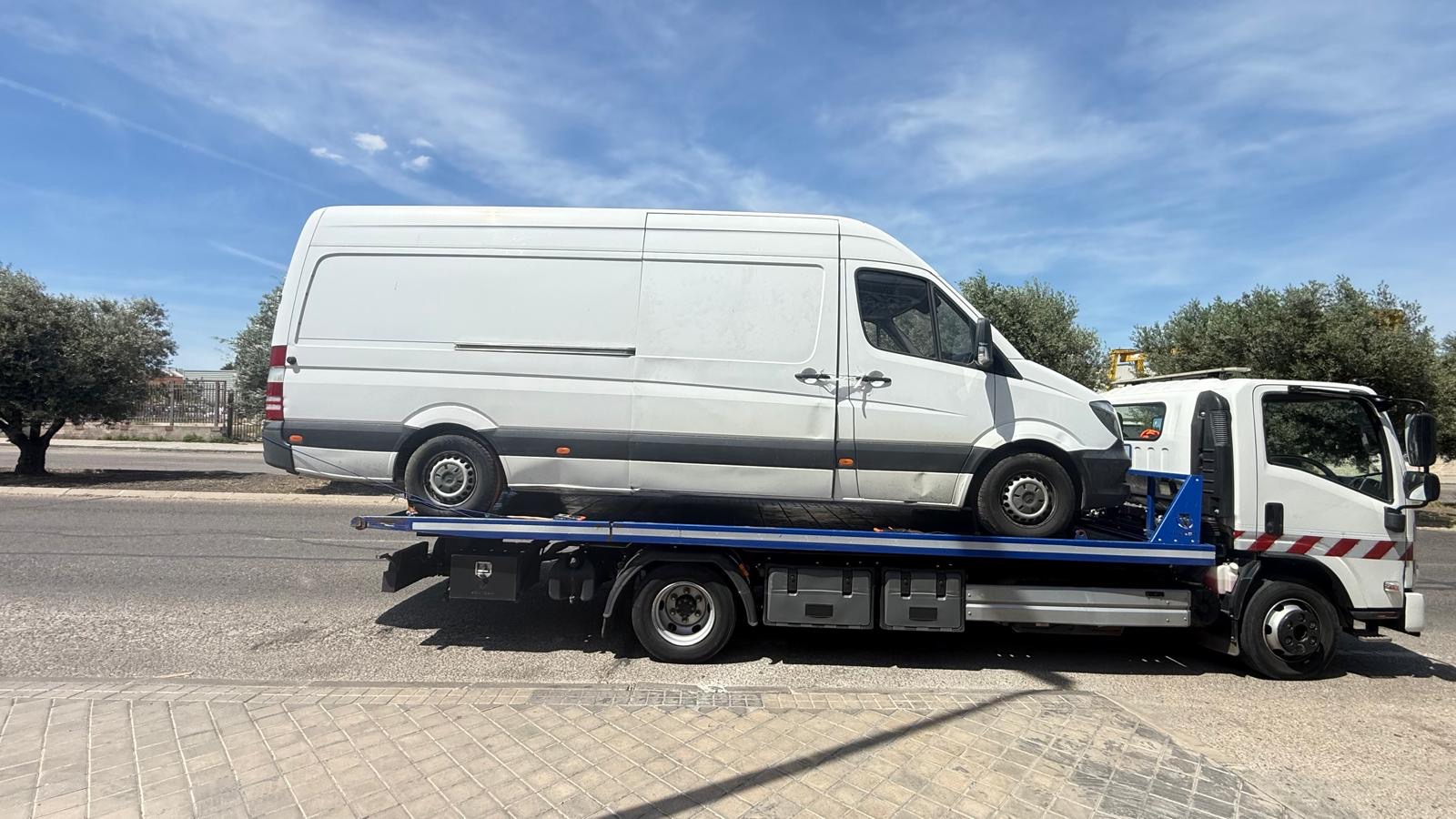 Grúa transportando una furgoneta de gran tamaño